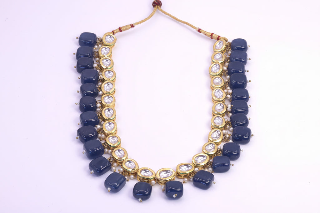 Necklace with blue beads and gold accents on a white background
