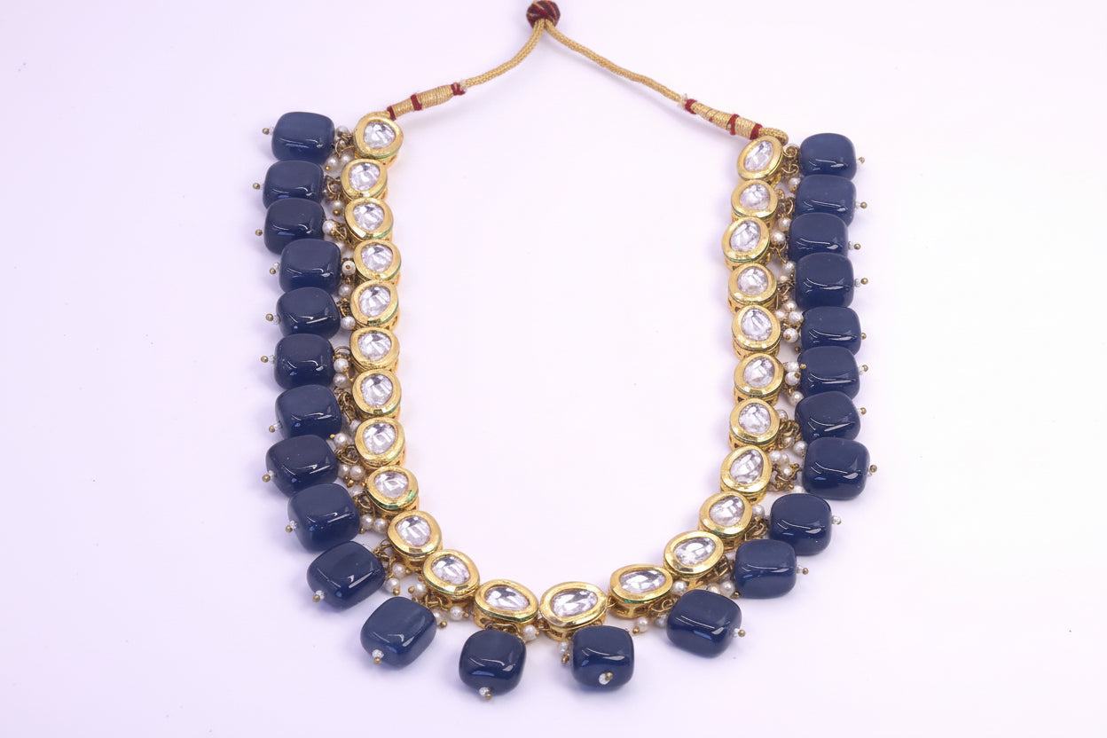 Necklace with blue beads and gold accents on a white background